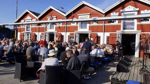 Billede af hyggestemning ved Skagen Fiskerestaurant, hvor en masse mennesker spiser sammen